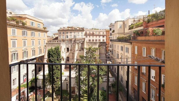 A view from a balcony overlooking a cityscape with historic buildings and a clear sky.