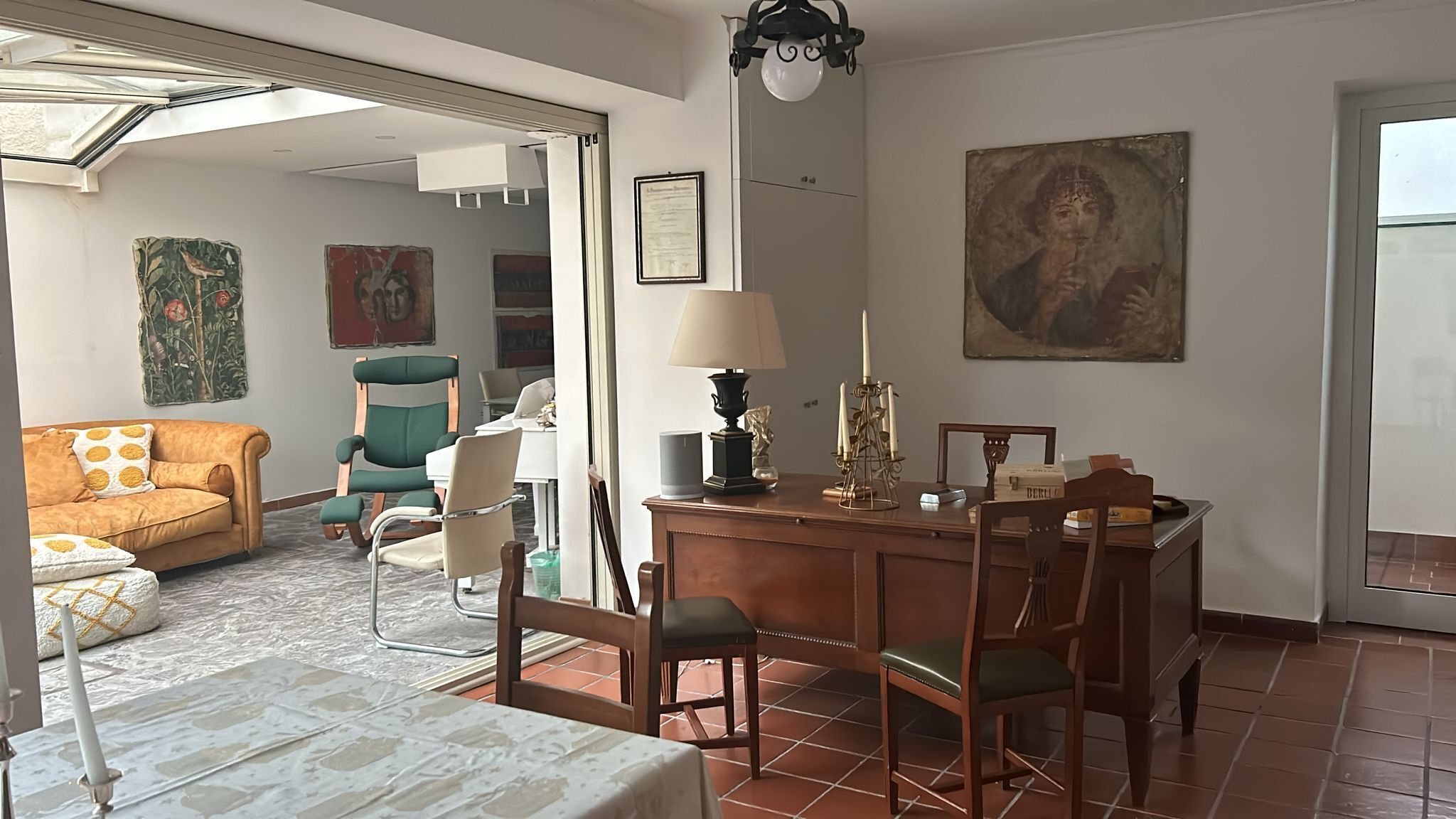 Un coin repas comprenant une table, des chaises, une lampe et un tableau accroché au mur.