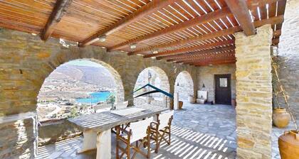 Villa traditionnelle en pierre avec un moulin Ă vent et une piscine Ă Koundouros