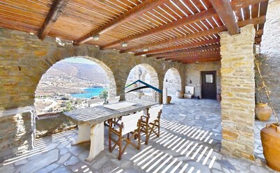 Traditional stone built villa with a windmill and a swimming pool in Koundouros