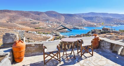 Villa tradicional de piedra con un molino de viento y una piscina en Koundouros
