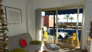 Una habitación con un sofá, una mesita y vistas al exterior.