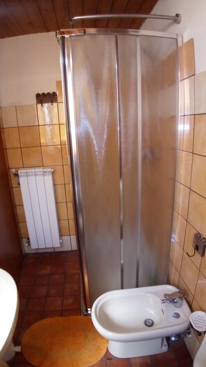 Bathroom features a shower enclosure, sink, and radiator.