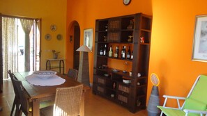 A dining area with a wooden table, wicker chairs, and a buffet cabinet.