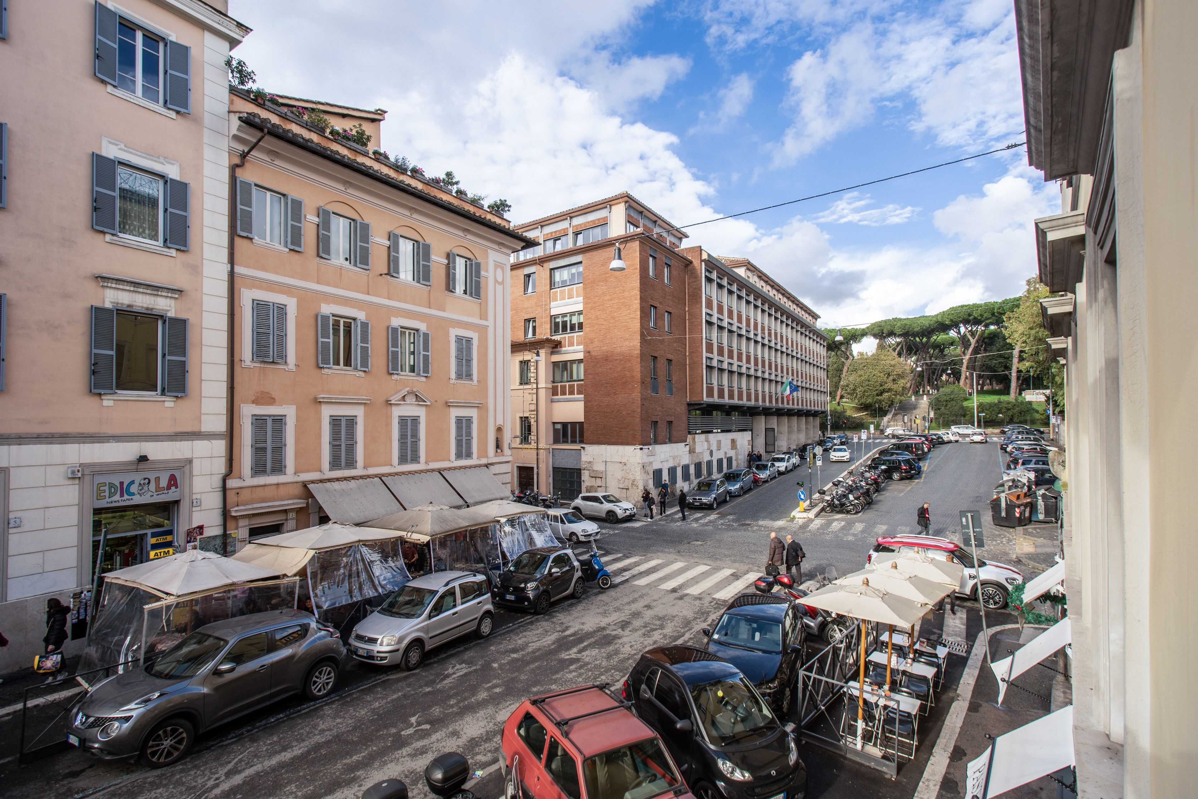 A street view with parked cars, buildings, and a crosswalk.