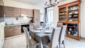 A modern kitchen with wooden cabinets, a dining table set for four, and a china cabinet. - Times Rome Colosseum, wide in wonderful location front Coliseum (Rome)
