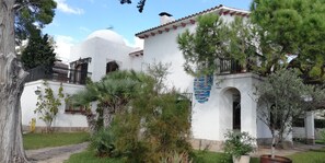 A white building with a dome and red-tiled roof, surrounded by greenery and a clear sky. - FABULOUS BEACHFRONT VILLA VERY CLOSE TO BARCELONA  (COMA RUGA)