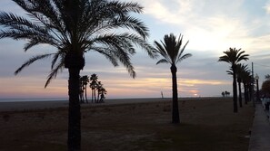 A beach with palm trees and a sunset in the background. - FABULOUS BEACHFRONT VILLA VERY CLOSE TO BARCELONA  (COMA RUGA)