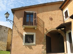 Experience the charm of this traditional building with a balcony and stone archway.