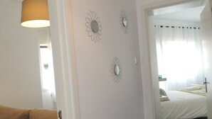 A hotel room with a bed, a sofa, and a hallway leading to another room. - RENDEZ VOUS PORTO I (T1) (Paranhos - Porto)