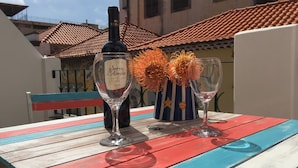 Un tavolo di legno colorato con una bottiglia di vino e due bicchieri.