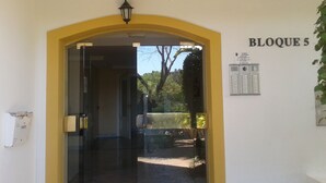 Un ingresso con porta in vetro, arco giallo e un cartello con la scritta "BLOQUE 5".
