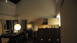 Une cuisine moderne avec un coin repas, comprenant une grande table à manger, des chaises et un luminaire suspendu.