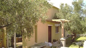 Un petit bâtiment doté d’une pergola, d’une fenêtre et d’une porte.