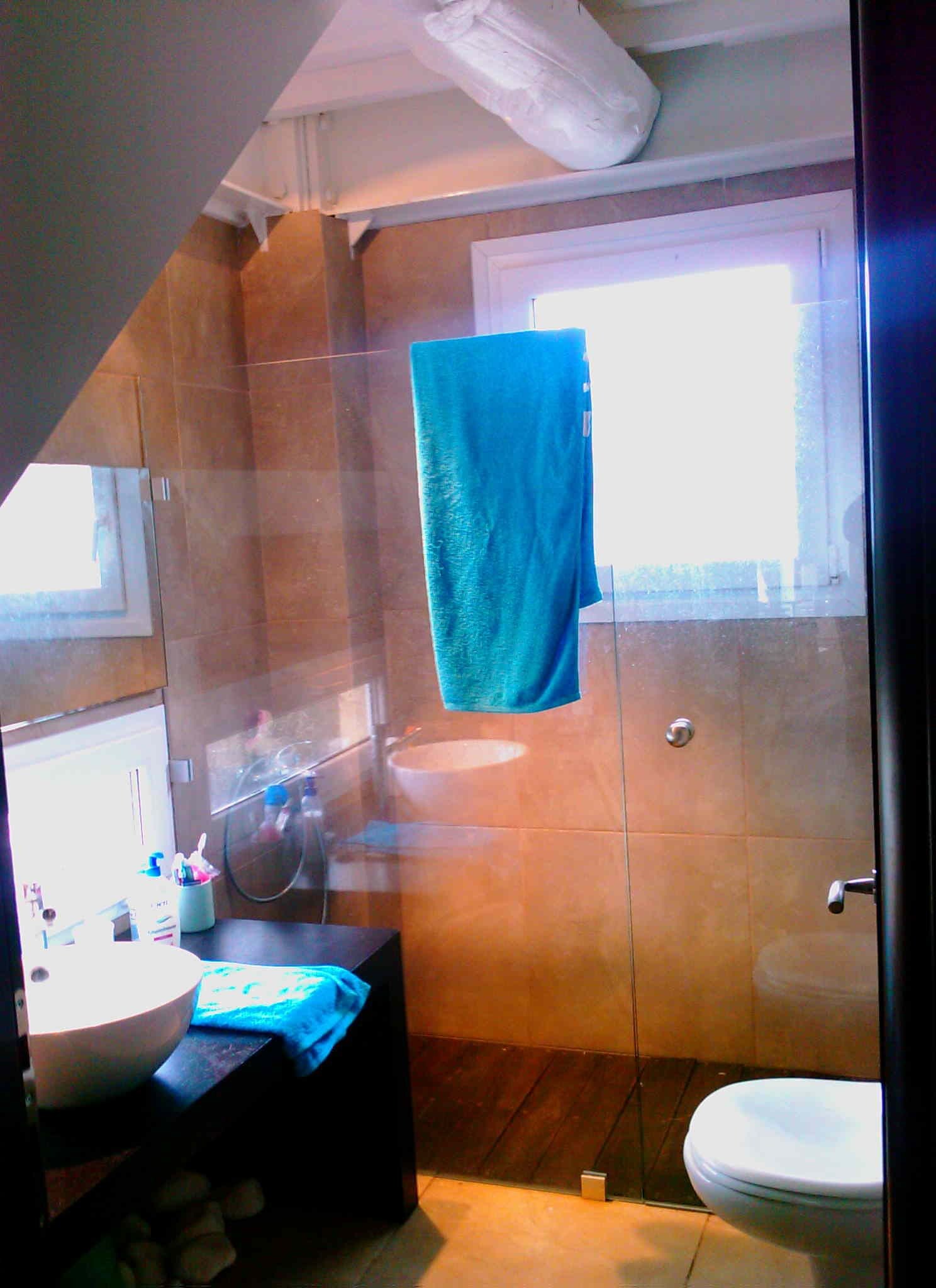 Un baño con ducha, lavabo e inodoro.