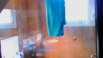 Un baño con ducha, lavabo e inodoro.