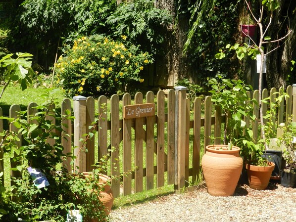 A wooden fence with a sign reading "Le Grenier" and several potted plants. - Gîte with pool, grounds, air-conditioning for peaceful family holidays in Landes (Sainte-Colombe)