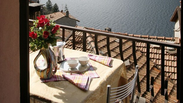 A terrace with a table set for two, overlooking a lake and mountains. - COLOR WITH PANORAMA AND RENOVATED PARKING (Careno)