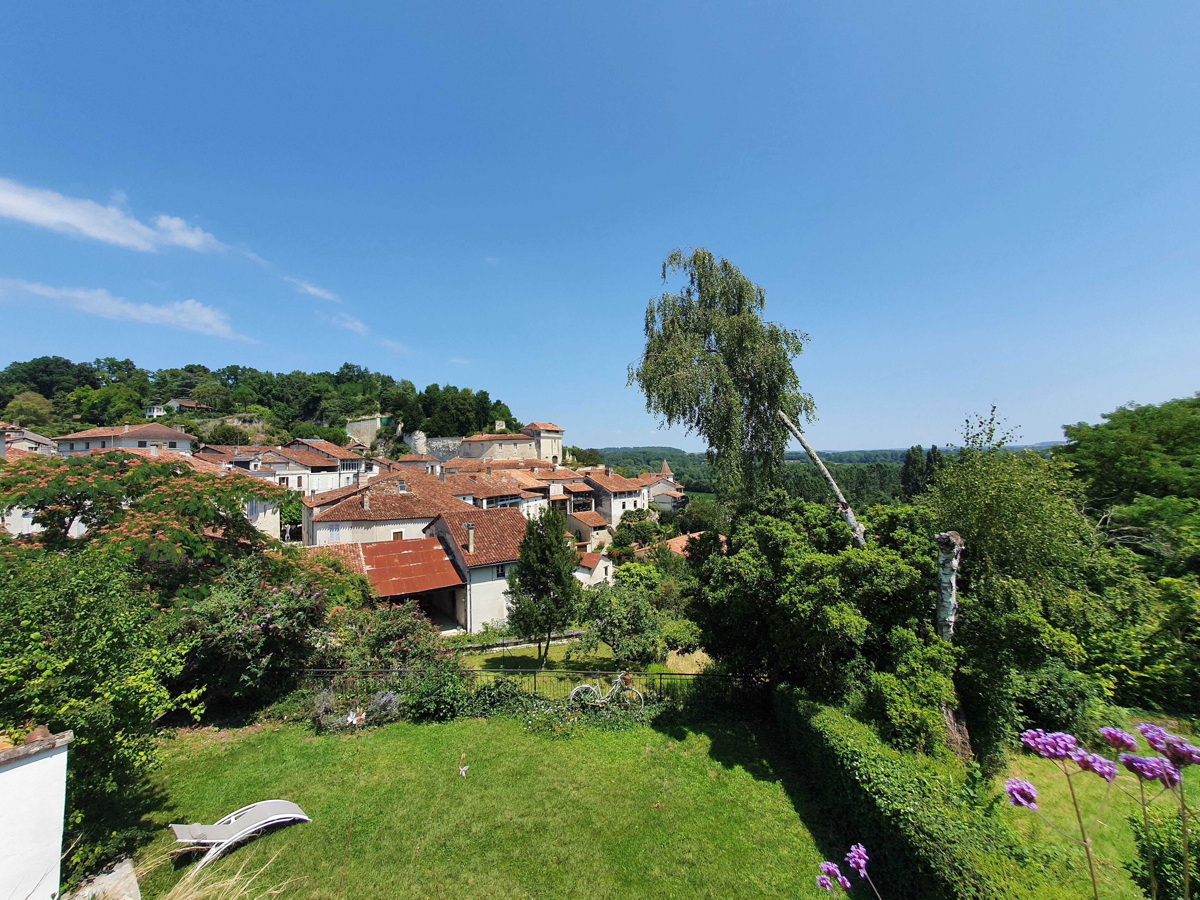 A residential area with houses, a grassy lawn, and a tree.
