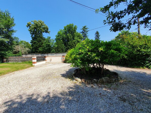 A gravel driveway leading to a gated entrance with a small tree in the center. - Le Mauguillard, Aubeterre Sur Dronne (Laprade)