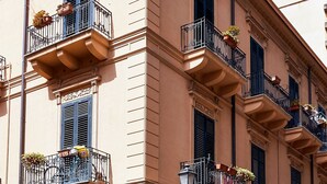 A multi-story building with balconies, a no-entry sign, and a street lamp.