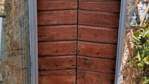 A wooden door with a metal frame, set in a stone wall.