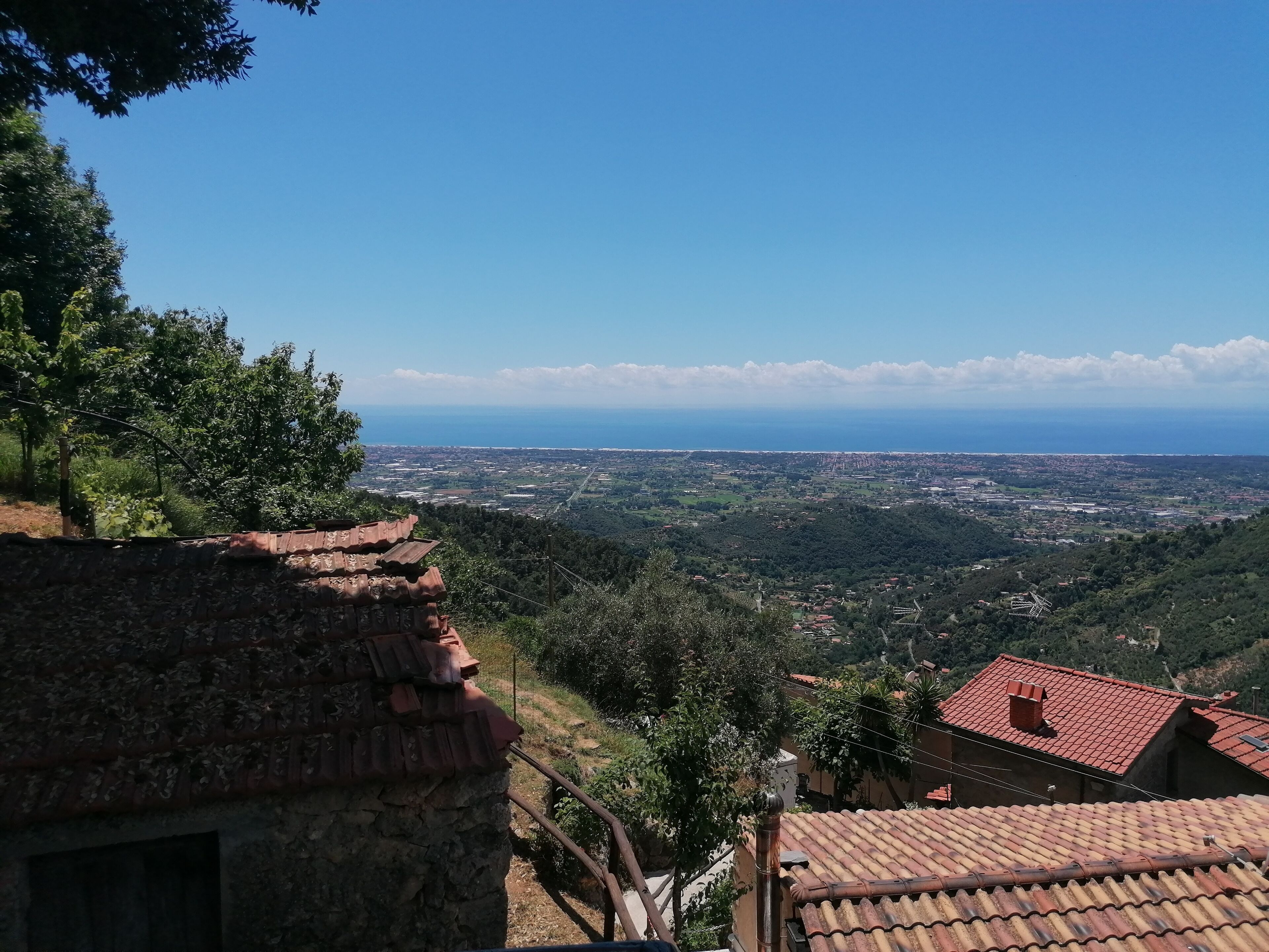 A view from a high vantage point overlooking a town with terraced houses and a clear blue sky.