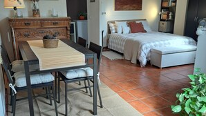 Een knus woongedeelte met een eethoek, een bed en een kitchenette.