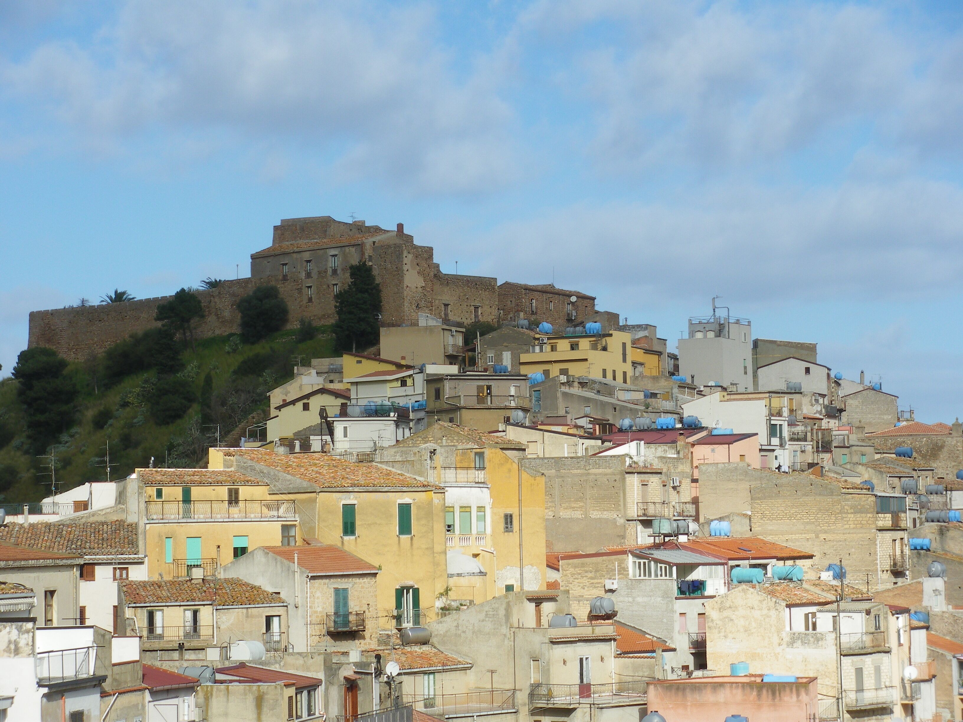 A historic hilltop town with a prominent castle-like structure.