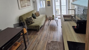 Ein zeitgemäßer Wohnraum mit Sofa, Esstisch und Küchenzeile.