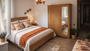 Une chambre à coucher comprenant un lit, une table de chevet, une lampe, une armoire en bois et un plancher à motifs.