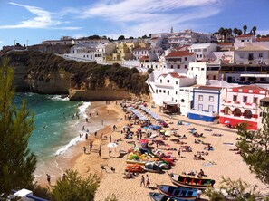 A beach with people, boats, and buildings in the background. - CARVOEIRO LUXURY & COMFORT APT. DESTINO (Carvoeiro)