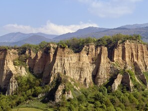 Un paisaje agreste con acantilados imponentes y vegetación escasa.