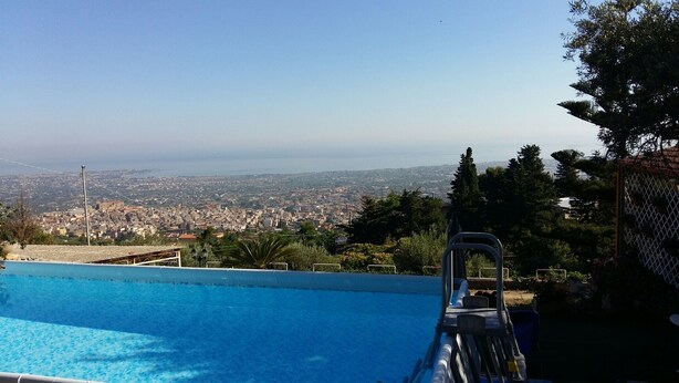 A swimming pool with a view of a cityscape and distant mountains.