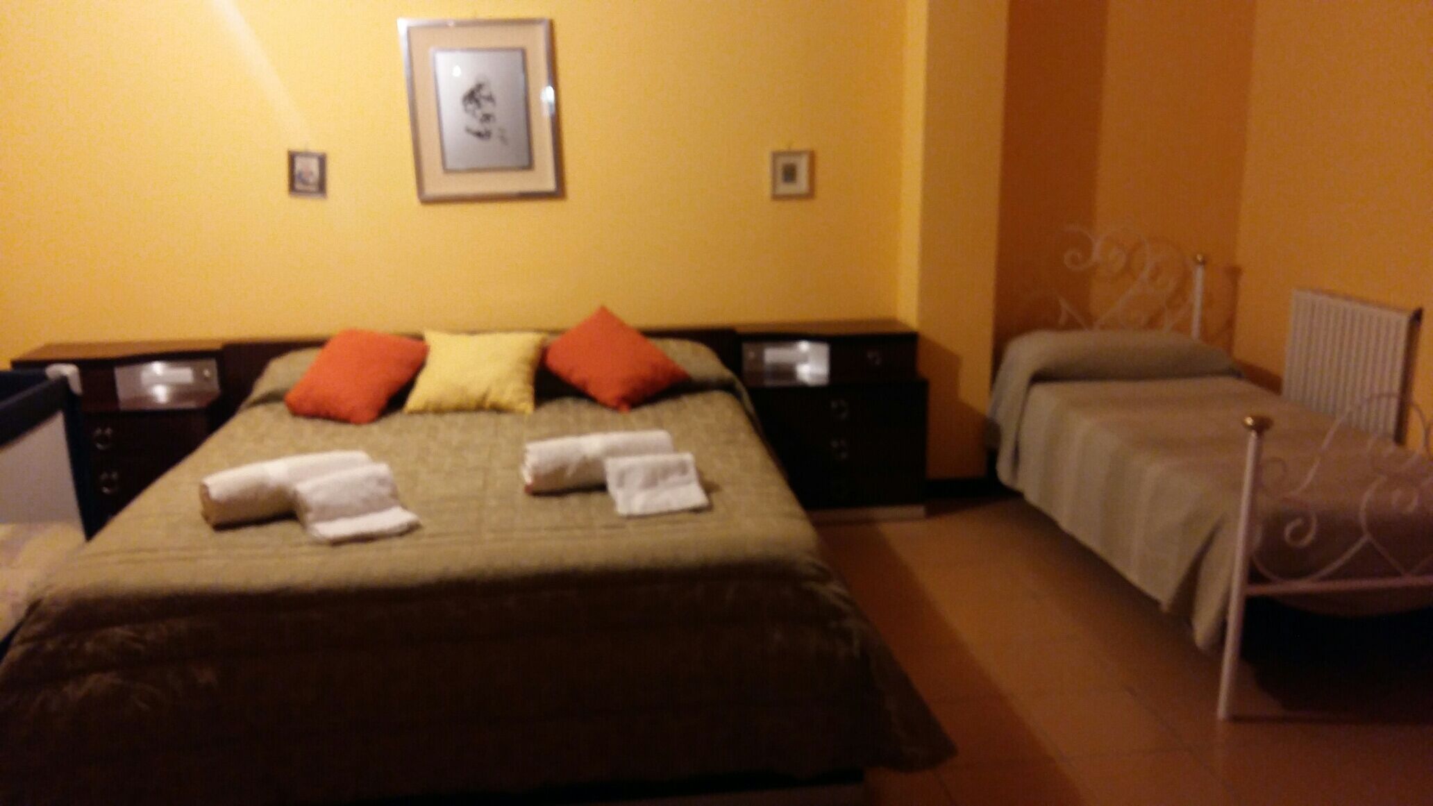 A hotel room with a bed, two bedside tables, a chair, and a picture on the wall.