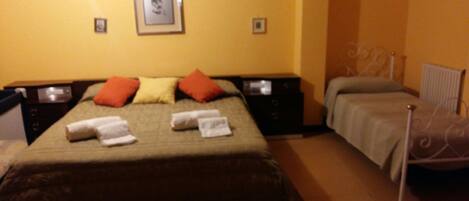 A hotel room with a bed, two bedside tables, a chair, and a picture on the wall.