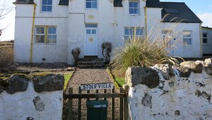 A white building with a yellow trim and a sign reading "STOER VILLA".