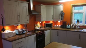 A kitchen with white cabinets, a microwave, a toaster, and a stove.