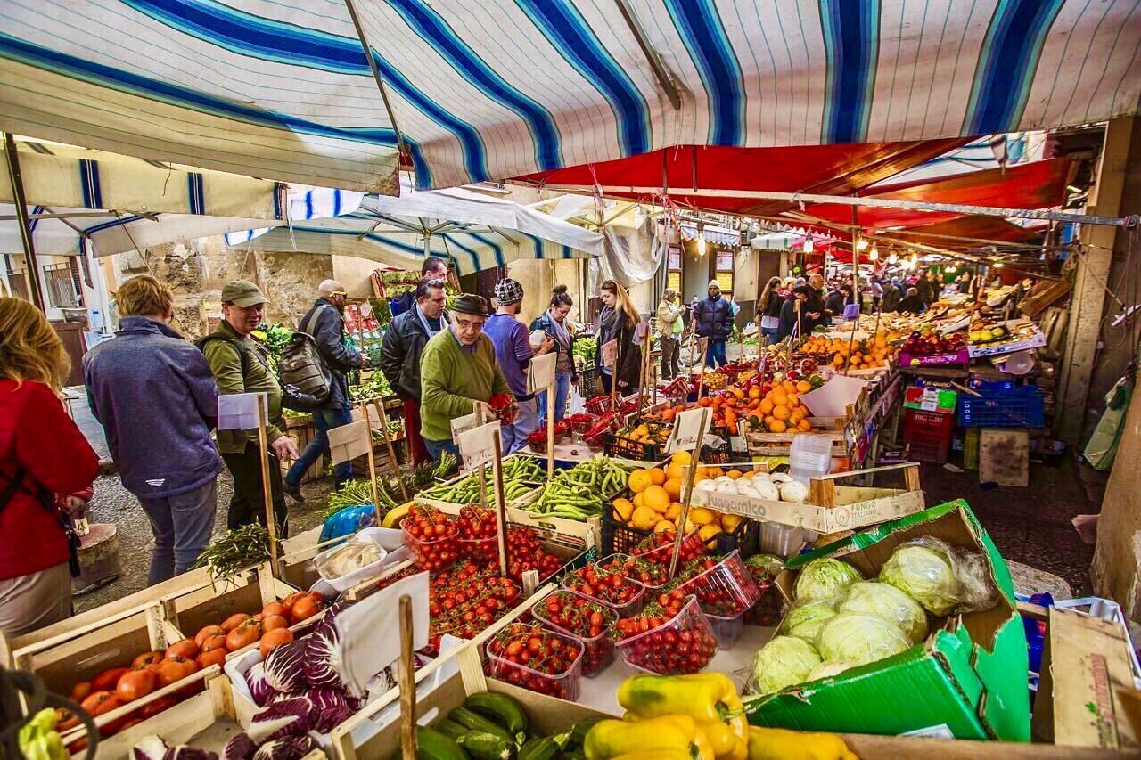 An indoor market with various stalls selling fresh produce and goods.