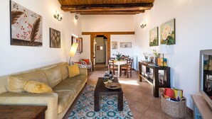 A living room with a sofa, coffee table, and artwork on the walls. - Bright Penthouse With Terrace On Via Maqueda, In The Heart Of The City (Palermo)
