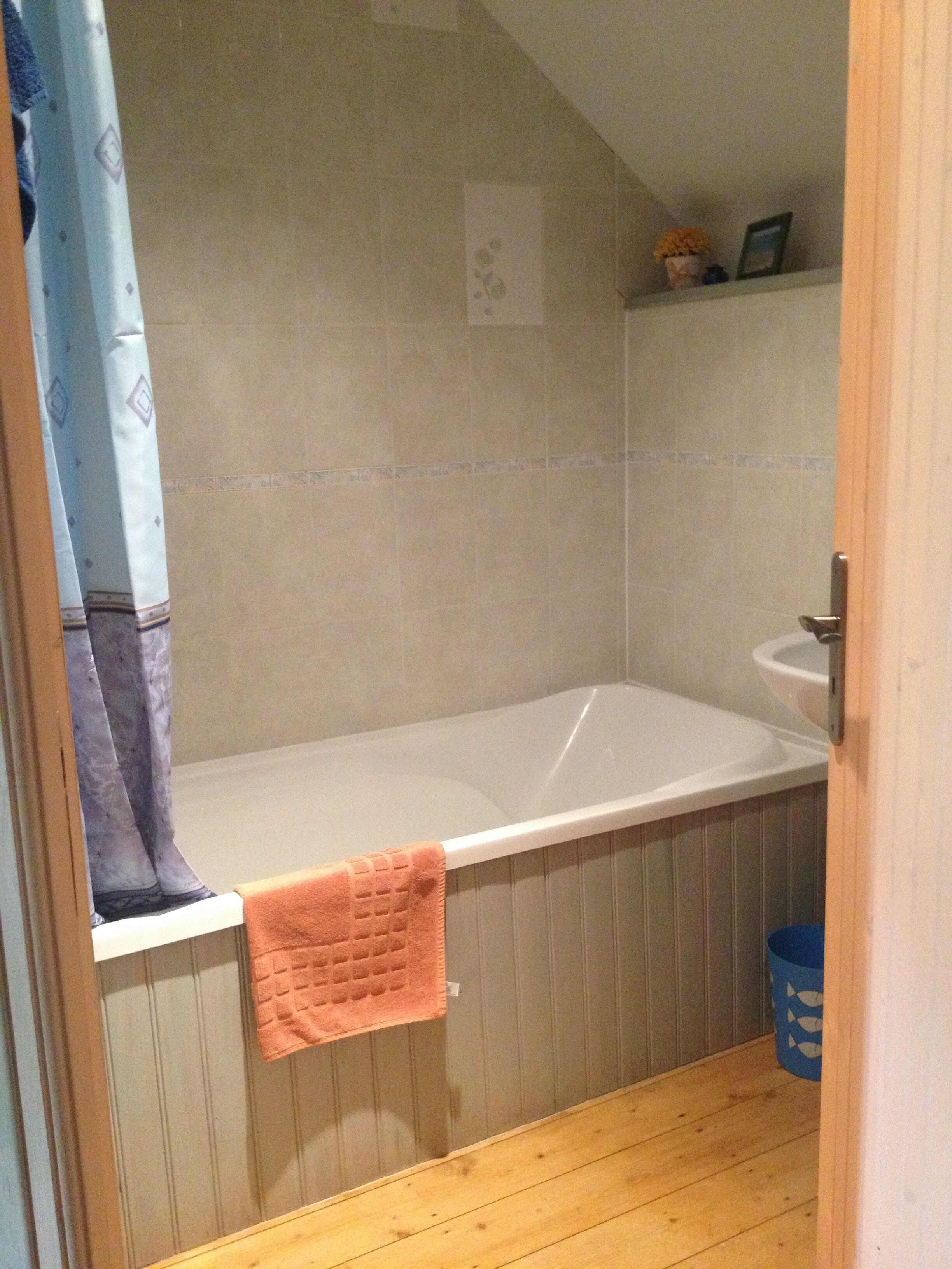 Une salle de bain avec une baignoire, un lavabo et un rideau de douche.