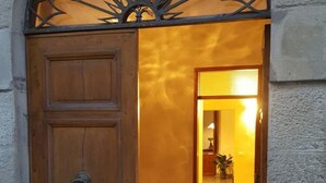 A wooden door with a metal decorative arch, leading into a warmly lit interior space. - "TERRACE BELL" (PANZANO IN CHIANTI)