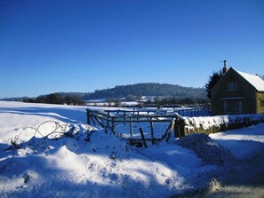 Escape to a serene countryside retreat with a traditional guesthouse surrounded by a peaceful, snow-covered landscape.