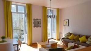 Ein Wohnzimmer mit einer Couch, einem Couchtisch und einem Essbereich mit Tisch und Stühlen.