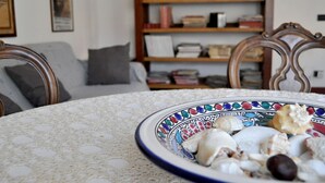 A dining table with a decorative plate of seashells and nuts. - Beautiful house in Villa Liberty  (Marina di pisa)