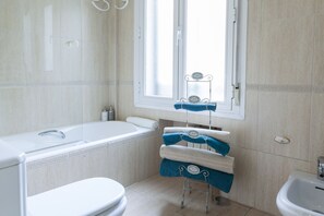 Bañera con ducha, secador de pelo, toallas, jabón