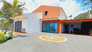 A modern house with a red roof, large glass windows, and a paved driveway with a star design. - Villa Luz: between Serra and the Sea - Free Wifi (Santa Cruz)