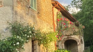 A rustic stone building with a small window and a brick archway. - Bargi House (Perugia)