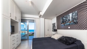 Une chambre avec un lit, une télévision et une vue sur l’océan.