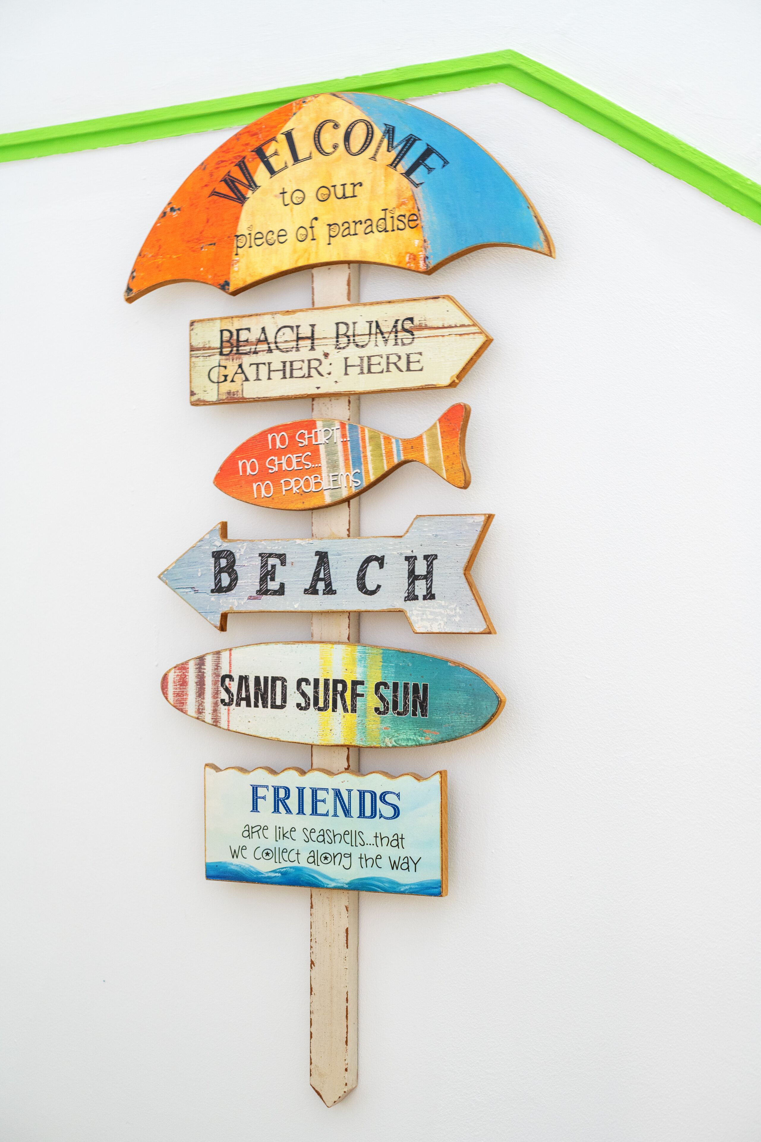 Une pancarte en bois portant diverses inscriptions sur le thème de la plage.